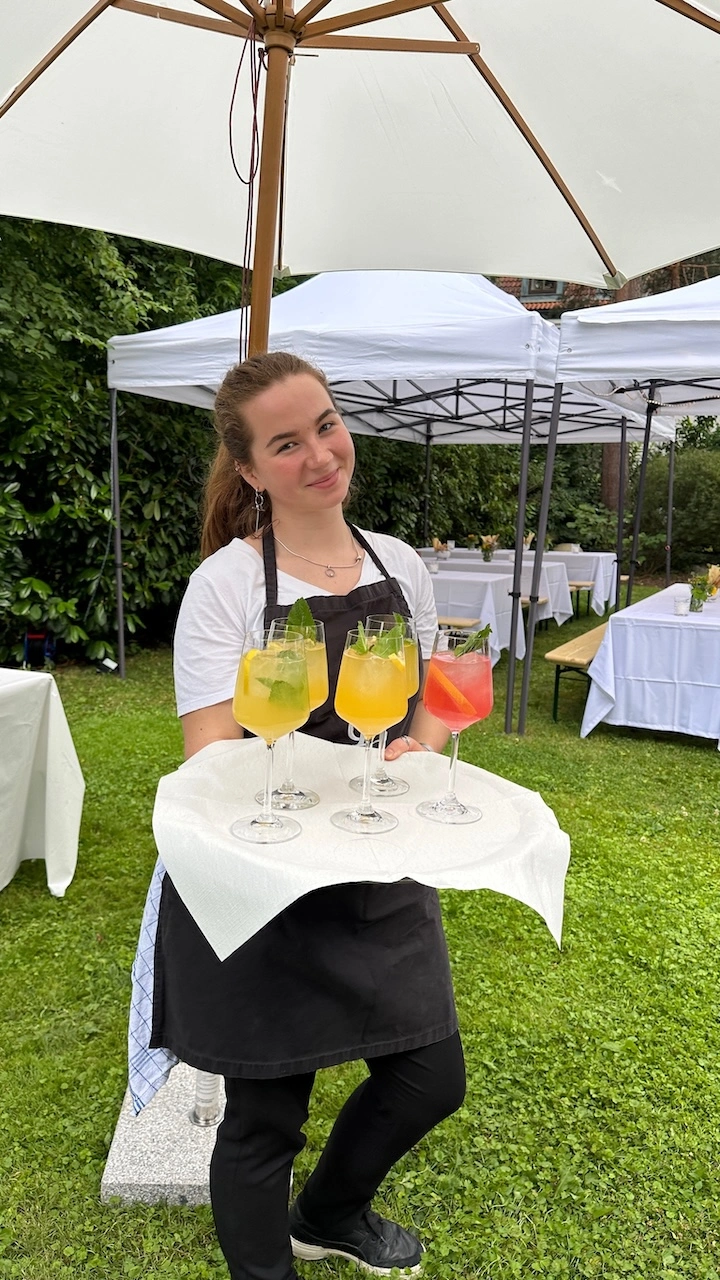 Hochzeitscatering München 31 Eine Service Kraft von CSL Catering München mit einem Signature-Cocktail Tablett